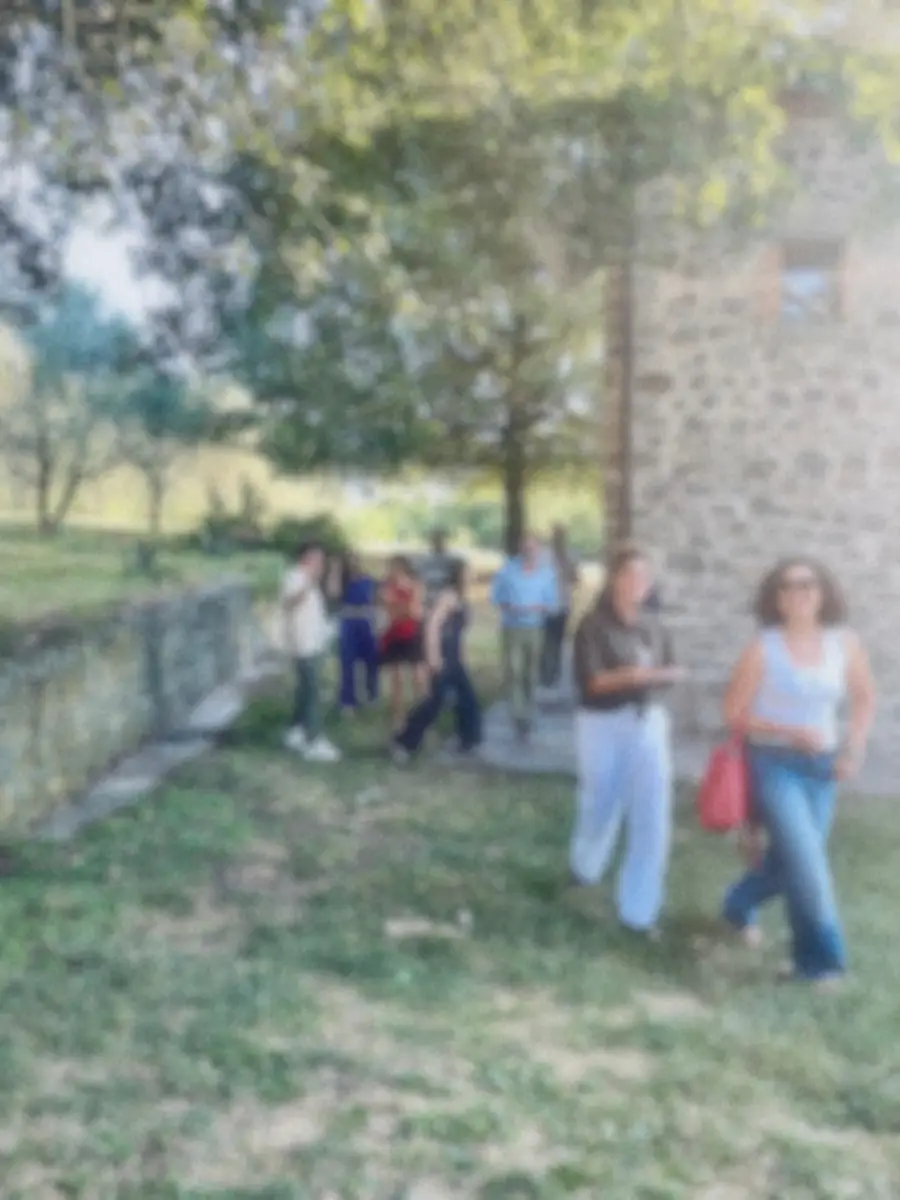 Un gruppo cammina sul prato accanto alla casa di Cornoleda durante una team experience